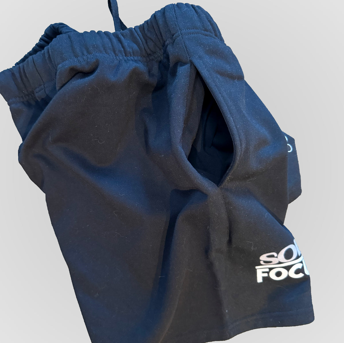 Dark blue drawstring shorts with 'SOLELY FOCUSED' logo on side hem.