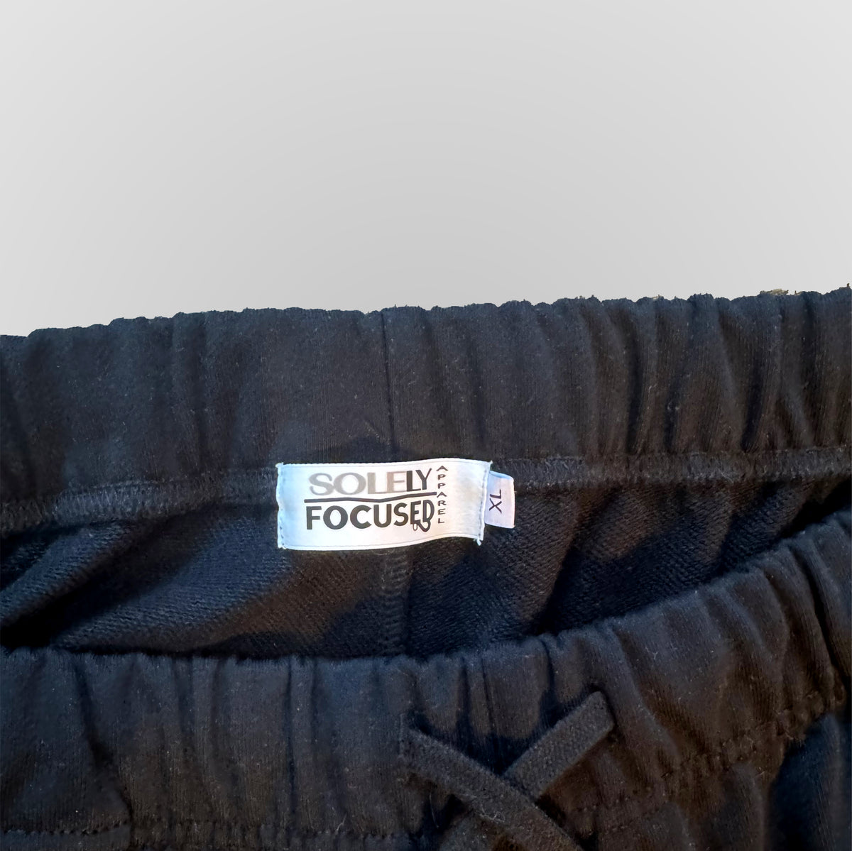Dark blue elastic waistband shorts with inner drawstring and size label.