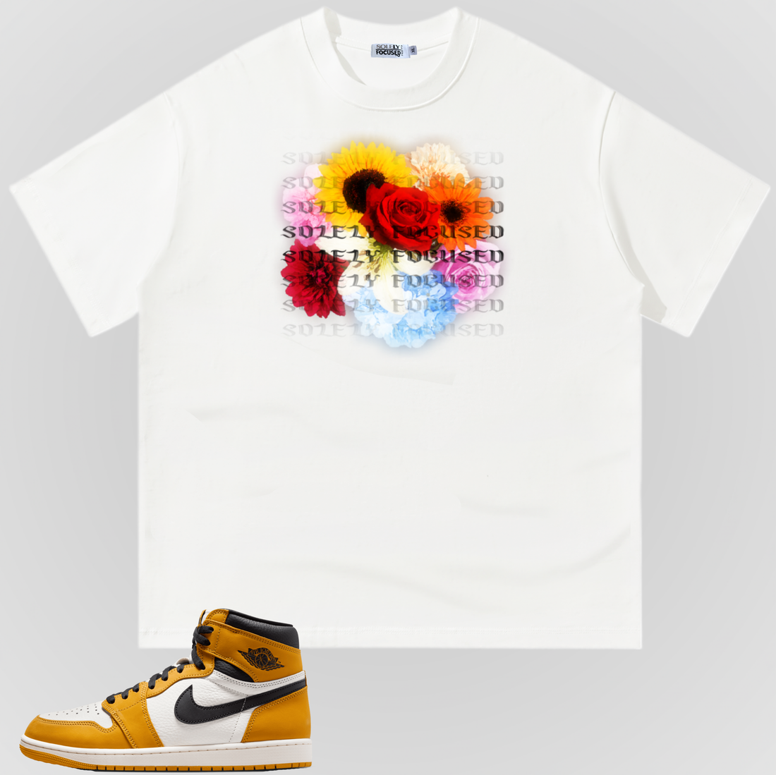 White GIVE ME MY FLOWERS TEE with a colorful floral chest graphic and repeated Solely Focused lettering, pictured above a yellow, white, and black sneaker.